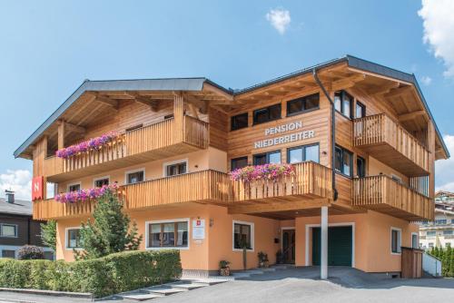a building with balconies and flowers on it at Pension Niederreiter in Maria Alm am Steinernen Meer