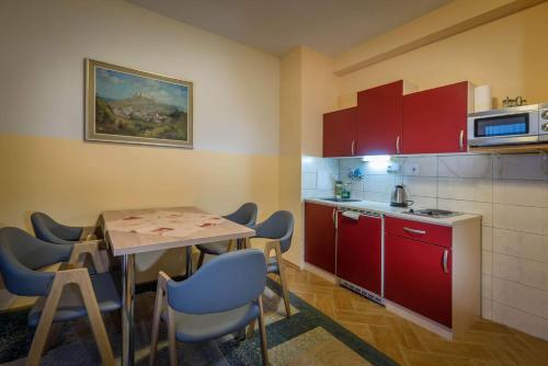 a kitchen with red cabinets and a table and chairs at Miramonti Apartmány in Smokovce