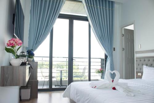 ein Schlafzimmer mit einem weißen Bett mit Herzdekoration in der Unterkunft Winston Hotel in Ho-Chi-Minh-Stadt