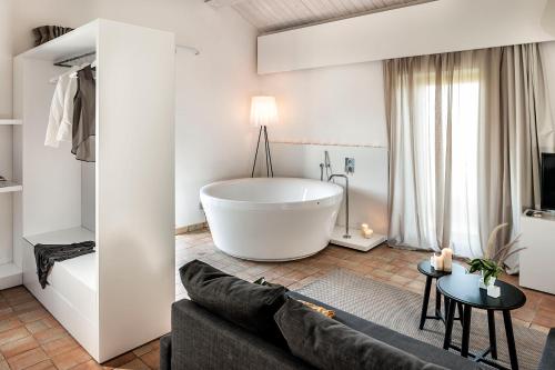 a large white bath tub in a living room with a couch at Ramo d'Aria Etna Boutique Hotel in Giarre