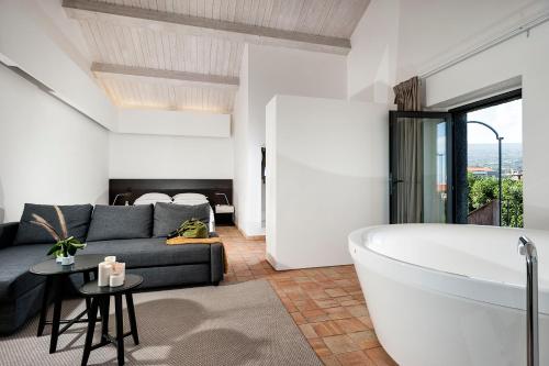 sala de estar con bañera y sofá en Ramo d'Aria Etna Boutique Hotel, en Giarre