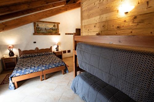 a bedroom with a bed and a wooden wall at Etoile des Neiges in Sauze dʼOulx