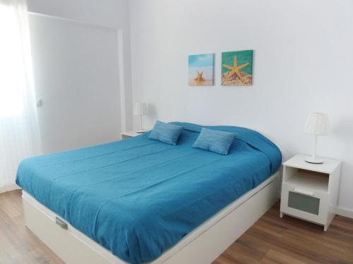 エストリルにあるOcean Breeze Apartmentのベッドルーム1室(青い毛布付きのベッド1台付)