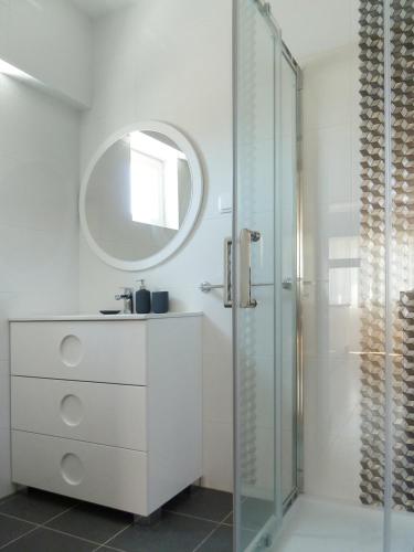 a white bathroom with a sink and a shower at Ocean Breeze Apartment in Estoril