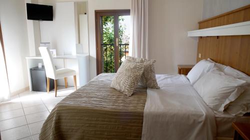 a bedroom with a bed with a chair and a window at Hotel EMI in Bologna