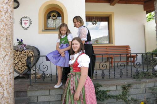 a woman and two girls standing on a porch at Ferienwohnungen Marchanger in Niederau