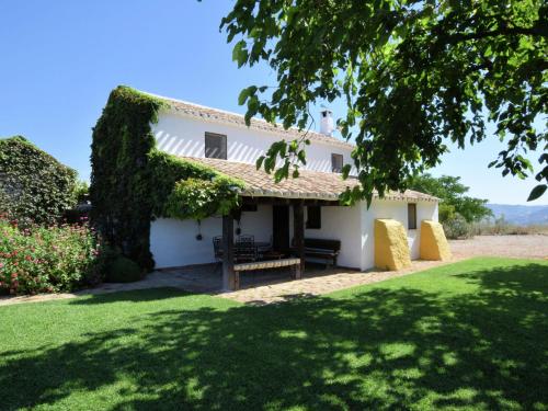 a white house with a green lawn in front of it at Belvilla by OYO Cortijo El Morron in Fuentes de Cesna