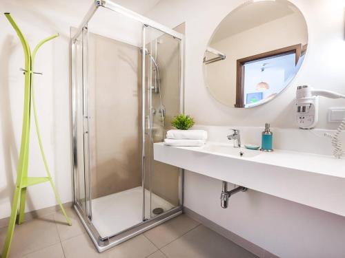 a bathroom with a shower and a sink and a mirror at VacationClub - Baltic Park Molo Apartament D305 in Świnoujście