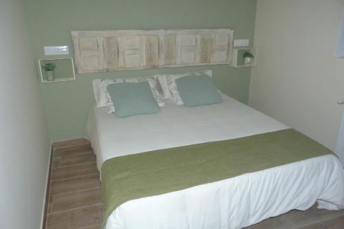 a bedroom with a large white bed with two pillows at Casa de Tintas in Cuenca