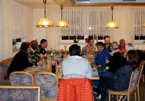 a group of people sitting at a table in a restaurant at Pension zum Ritter in Katzhütte