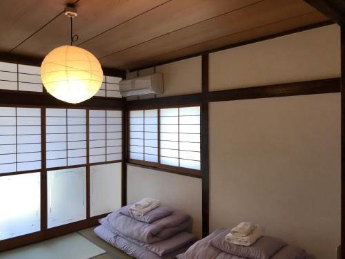 two beds in a room with windows and a lamp at west crab base in Hiroshima