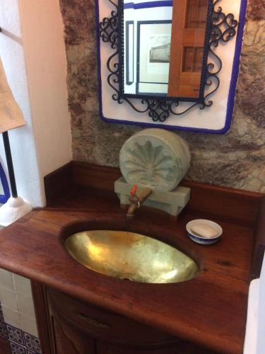 a bathroom with a gold sink and a mirror at Sanbernabé tres in Guanajuato