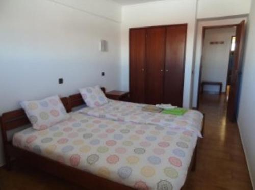 Schlafzimmer mit einem Bett mit Polka-Punkten-Bettwäsche in der Unterkunft Beach apartment... T1 with swimming pool (summer) in Costa da Caparica
