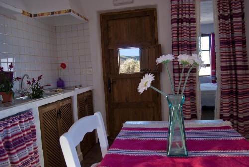 a vase with flowers on a table in a kitchen at Olivares Rural in Los Albaricoques