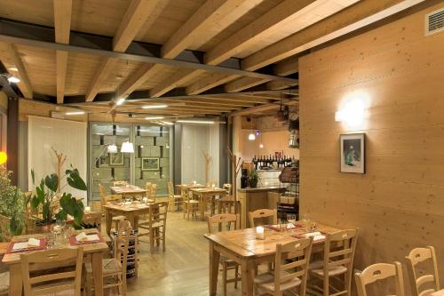 uma sala de jantar com mesas e cadeiras de madeira em Locanda Tana de 'l Ors em Val di Zoldo