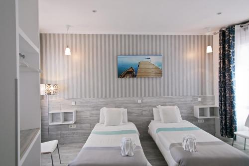 a room with two beds and a tv on the wall at Hostal Main Street Madrid in Madrid