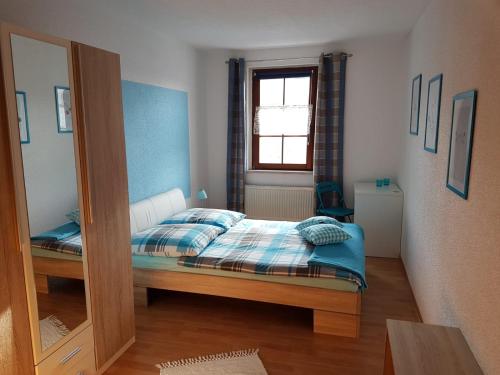 a small bedroom with a bed and a mirror at Ferienwohnung am Schwarzwasser in Schwarzenberg