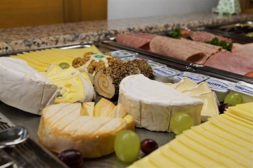 a tray of different types of cheese and grapes at Hotel St.Martiner Castell in Sankt Martin