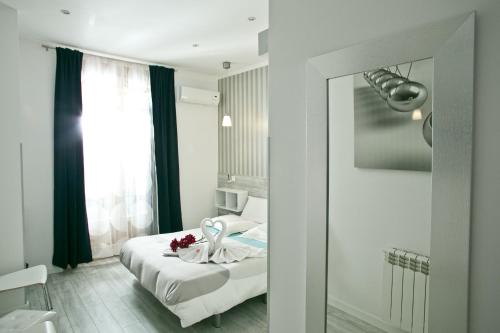a bedroom with a bed with a mirror and a window at Hostal Main Street Madrid in Madrid