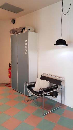 a chair in a room next to a refrigerator at hotel garni Santa Caterina in Orta San Giulio