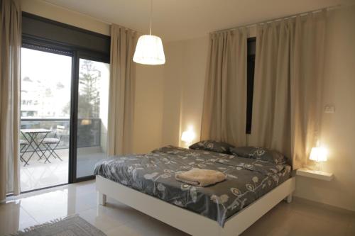 a bedroom with a bed and a sliding glass door at Ramallah Modern Apartment in Ramallah