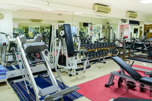 a gym with rows of tread machines and a mirror at La Rosa Hotel, Juffair in Manama