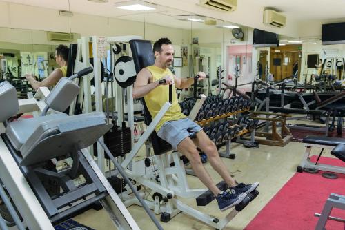 a man sitting on a bench in a gym at La Rosa Hotel, Juffair in Manama