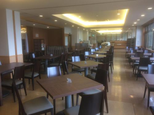 a row of tables and chairs in a restaurant at Hotel Route-Inn Kawaguchiko in Fujikawaguchiko