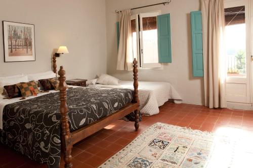 a bedroom with two beds and a window at Turisme Rural Mas Masaller in Cruïlles