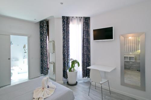 a bedroom with a bed and a desk and a television at Hostal Main Street Madrid in Madrid