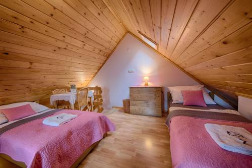 a attic room with two beds and a table at Chata Góralska Aggeusz in Wisła