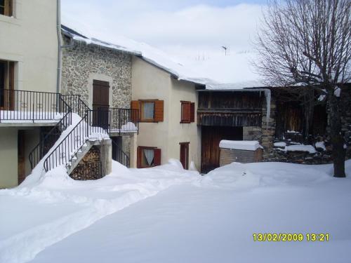um quintal coberto de neve com uma casa e escadas em Gites Ardoise et Girolle Formiguères em Formiguères