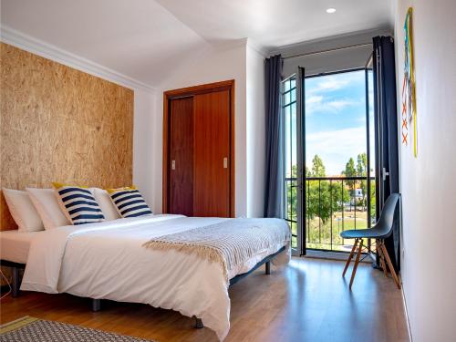 a bedroom with a large bed and a sliding glass door at Azuleixo in Aveiro