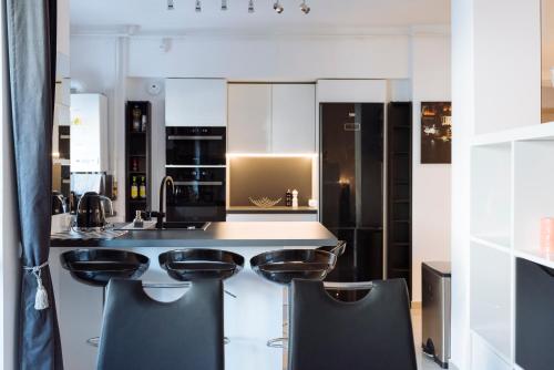 eine Küche mit weißen Schränken und schwarzen Geräten in der Unterkunft Luxury Flat 8 near Metro in Bukarest