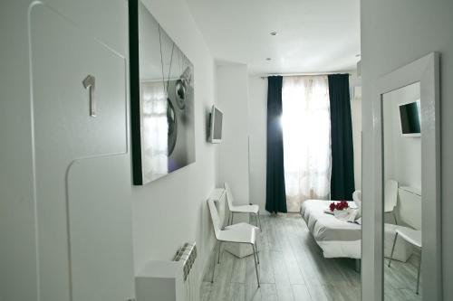 a white room with a bed and a window at Hostal Main Street Madrid in Madrid