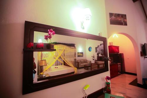 a mirror hanging on the wall of a room at SRI LANKAN VILLA in Galle
