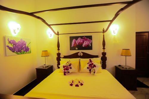 a bedroom with a bed with flowers on it at SRI LANKAN VILLA in Galle