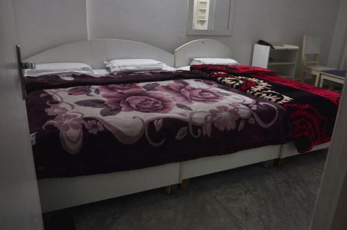 una camera da letto con un letto con copriletto floreale di Hotel Green Palace New a Nuova Delhi