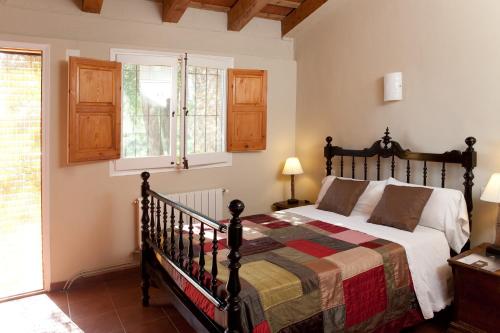 a bedroom with a large bed and a window at Turisme Rural Mas Masaller in Cruïlles
