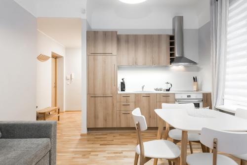 a kitchen with a white table and white chairs at Kuninga City Center Apartment in Pärnu