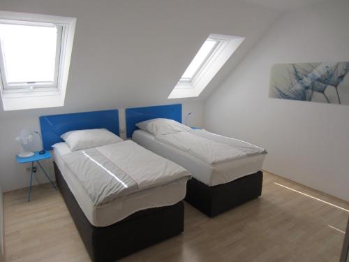 two beds in a room with two windows at Appartement Munz in Kirchheim unter Teck