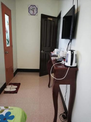 a room with a desk with a television and a computer at Balai Mariacaria Pension House in Guindulman
