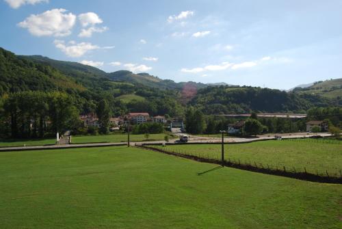 a green field with mountains in the background at Casa rural Lakoizketa in Legasa