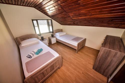 a room with two beds and a wooden ceiling at Vacation house Nina in Sukošan