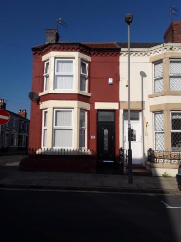 a red and white house with a black door at 39 Cowley Road in Liverpool