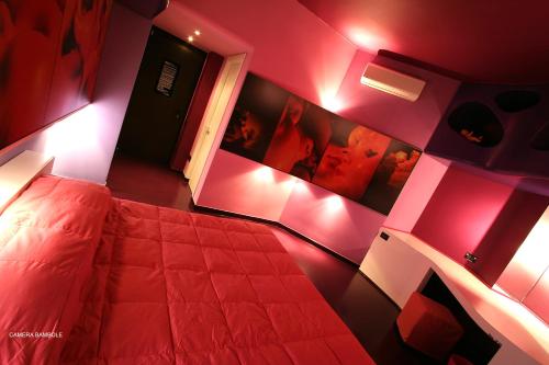 a bedroom with a bed with pink walls and lights at Diecizero Affittacamere in Barùmini