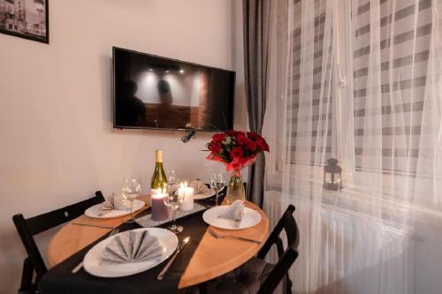 a dining room table with two chairs and a television at DIETLA 99 APARTMENTS - IDEAL LOCATION - in the heart of Krakow in Kraków