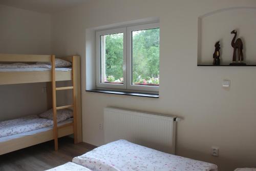 a bedroom with two bunk beds and a window at Apartmán Beskydy in Halenkov