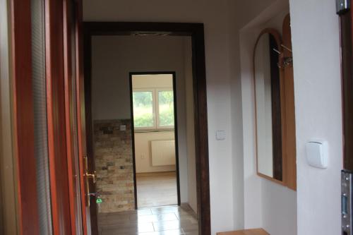 un pasillo con una puerta que conduce a una habitación con ventana en Apartmán Beskydy en Halenkov