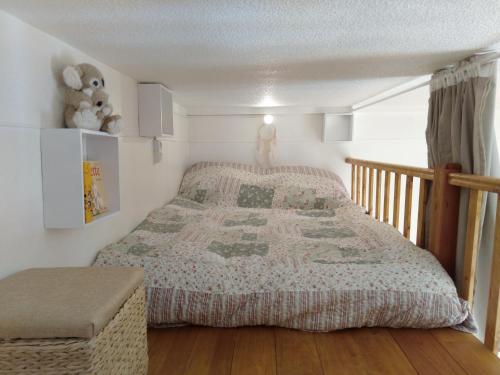 a bedroom with a bed with a quilt on it at Le Pardeilhan in Luchon